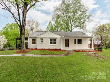 Charming single-story white brick home with well-manicured lawn and inviting front porch at 1113 Gregory Ln, Statesville, NC 28677
