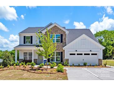 Beautiful two-story home featuring brick and white siding with a well-manicured front yard and a two-car garage at 130 Fordham Ct # 18, Fort Mill, SC 29715