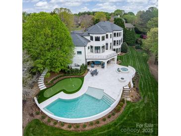 Stunning aerial view of backyard featuring in-ground pool, putting green, spa, patio and manicured lawn at 15603 Mccullers Ct, Charlotte, NC 28277