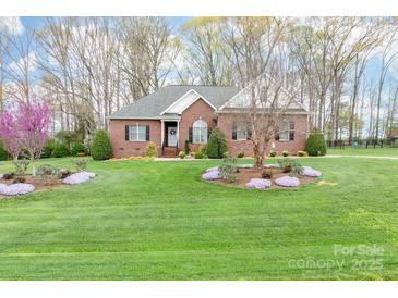 Beautiful brick home featuring a lush green lawn and meticulously landscaped front yard at 158 Canopy Oak Ln, Statesville, NC 28625