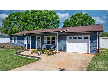 Charming single-story home featuring a blue exterior, a well-manicured lawn, and a cozy front porch at 2430 Rocky Ford Rd, Newton, NC 28658