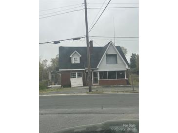 Exterior of building showing brick and paneled siding with a dark roof and several windows and a partial view of a street at 1214 Pee Dee Ave, Albemarle, NC 28001