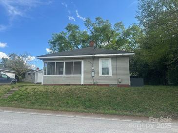 Charming single-story home with neutral siding, screened porch and neat landscaping under blue skies at 211 W 2Nd St, Kershaw, SC 29067