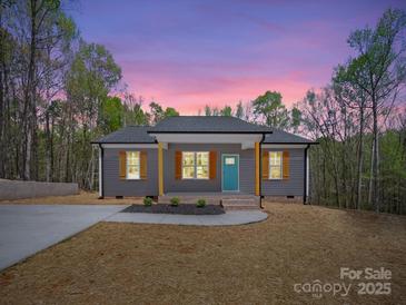 Charming single-story home featuring a light gray exterior, vibrant blue front door, and lovely landscaping at 297 Barr Link Rd, Mount Pleasant, NC 28124