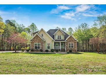 Charming home with stone accents, a covered porch, and a lush front yard at 3207 Oak Ridge Cir, Lincolnton, NC 28092
