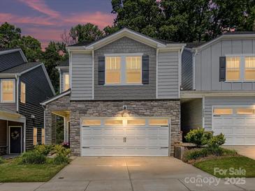 Charming townhouse with a two-car garage, stone accents, and manicured landscaping at 3524 Auburn Curb Rd, Charlotte, NC 28217