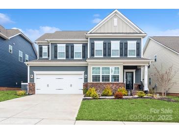 Charming two-story home with a well-maintained lawn, a two car garage and beautiful landscaping at 4024 Whipcord Dr, Waxhaw, NC 28173