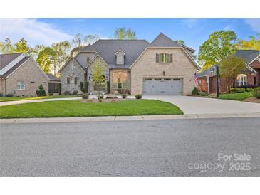 Charming brick and stone home with a well-manicured lawn and attached two-car garage at 4025 Foxes Trl, Cramerton, NC 28032