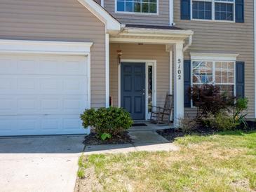 Inviting front entrance with a rocking chair and neat landscaping, adjacent to the garage at 5102 Candleglow Ct, Indian Trail, NC 28079