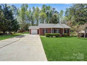 Charming brick ranch home with a well-manicured front lawn, a single-car garage, and a long driveway at 6549 Wesbrook Dr, Charlotte, NC 28214