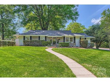 Charming single-story home boasts a lush green lawn and inviting walkway at 700 Cooper Dr, Charlotte, NC 28210