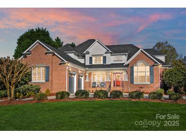 Charming brick home with a landscaped yard, two-car garage, and inviting front porch at 1404 Churchill Downs Dr, Waxhaw, NC 28173