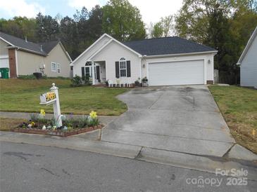 Charming one-story home features a manicured lawn, flowerbeds, and a two-car garage at 158 Margaret Turner Rd, Charlotte, NC 28216