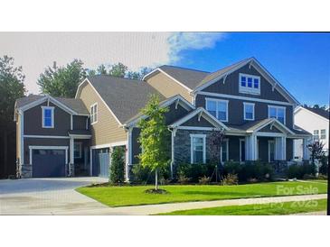 Beautiful two-story home with a three-car garage, stone accents, manicured lawn and mature landscaping at 2731 Oxbow Ct, Fort Mill, SC 29708