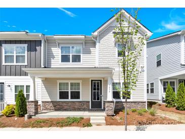 Charming two-story townhome featuring a stone-accented porch and well-maintained landscaping under a bright blue sky at 5850 Strathmore Ct, Charlotte, NC 28215