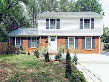Charming two-story home featuring a classic brick facade and manicured front yard landscaping at 6430 Farmingdale Dr, Charlotte, NC 28212