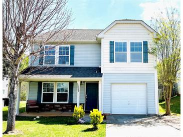 Charming two-story home featuring a covered porch, attached garage, and well-maintained lawn at 7928 Ponderosa Pine Ln, Charlotte, NC 28215
