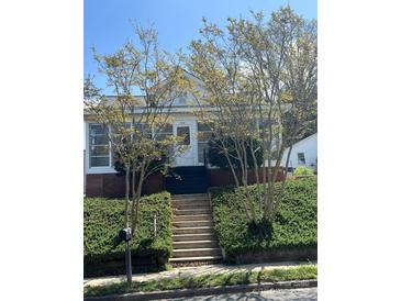 Charming home featuring a welcoming front yard with lush greenery and inviting entrance stairs at 818 N 4Th St, Albemarle, NC 28001