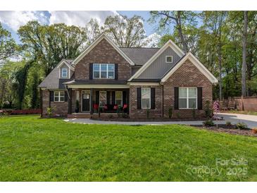 Beautiful two-story brick home with a manicured lawn and inviting front porch at 8209 Bella Vista Ct, Charlotte, NC 28216