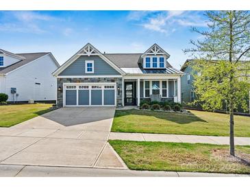 Charming home with blue siding, stone accents, and a well-manicured lawn at 8718 Festival Way, Charlotte, NC 28215