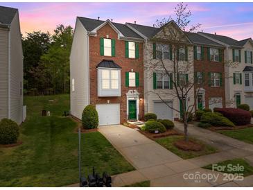 Charming townhome boasts brick facade, green shutters, and a well-manicured lawn at 10308 Garrett Grigg Rd, Charlotte, NC 28262