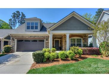 Charming home featuring stone accents, a covered front porch, and a well-maintained lawn and landscape at 14917 Dewpoint Pl, Huntersville, NC 28078