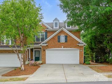 Charming two-story brick home with a two-car garage, manicured lawn, and colorful landscaping at 15643 Canmore St, Charlotte, NC 28277