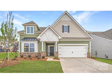 Charming two-story home with a manicured lawn, stone accents, and a two-car garage, creating an inviting curb appeal at 1996 Copper Path Dr, Fort Mill, SC 29715
