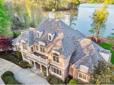 Luxury lakefront home featuring an expansive roof, manicured landscaping, and waterfront views at 210 Dexter Ave, Kannapolis, NC 28081