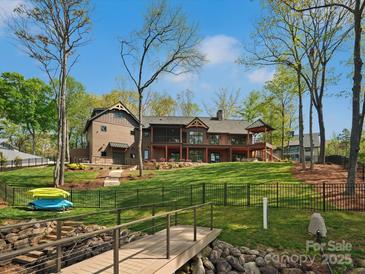 Large backyard with lush lawn, beautiful landscaping, a dock, and spacious back porch perfect for entertaining at 111 Milledge Dr, Mooresville, NC 28117