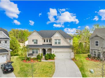 Charming two-story home with a well-manicured lawn, a covered porch, and a two-car garage at 12305 Stinson Ct, Charlotte, NC 28277