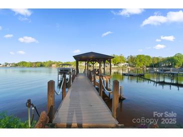 Picturesque lake view from a private covered dock with boat lift ready for summer fun at 20428 Island Forest Dr, Cornelius, NC 28031