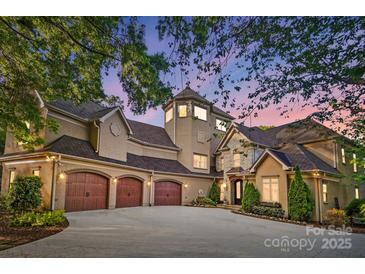 Elegant stucco home featuring three-car garage, stone accents, tower detail and beautifully landscaped front yard at 20428 Island Forest Dr, Cornelius, NC 28031