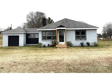 Charming single-story brick home with a black garage door and a welcoming front entrance at 2404 Old Camden Hwy, Lancaster, SC 29720