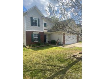 Charming home with a well-maintained lawn, brick accents, and an attached two-car garage at 7024 Sunman Rd, Charlotte, NC 28216