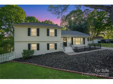 Charming two-story home featuring a well-manicured lawn and inviting front porch at 8025 Cliffside Dr, Charlotte, NC 28270