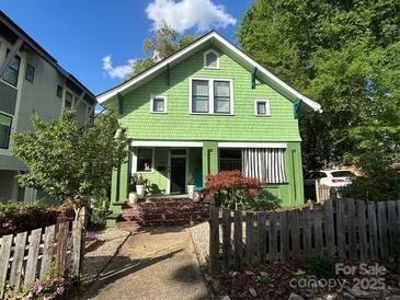 Charming two-story home with a bright green exterior, inviting front porch, and well-manicured landscaping at 1000 Margaret Brown St, Charlotte, NC 28202