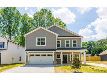 Charming two-story home featuring a two-car garage, gray siding, and a beautifully landscaped front yard at 1032 Dooley Dr, Charlotte, NC 28227