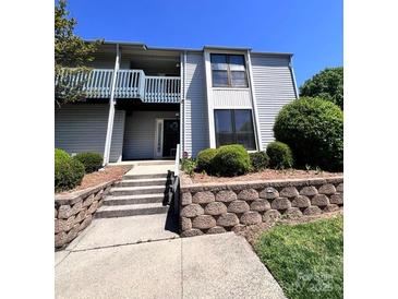 A charming condominium building with a second story balcony and landscaped entrance at 11015 Harrowfield Rd, Charlotte, NC 28226