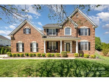 Charming brick home featuring a manicured lawn and beautiful, symmetrical landscaping at 2003 Ptarmigan Ct, Waxhaw, NC 28173