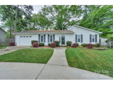 Charming one-story home with well-manicured lawn and walkway, black shutters, and attached garage at 22025 Torrence Chapel Rd, Cornelius, NC 28031
