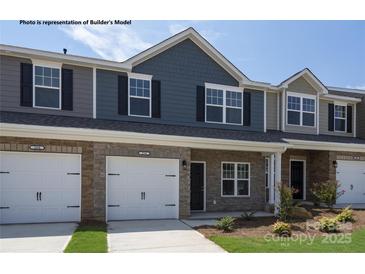 Charming townhome featuring stone accents, a one car garage, and manicured landscaping at 5345 Cherrie Kate Ct # 1804, Stanley, NC 28164