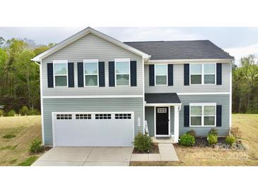 Charming two-story home with gray siding, black shutters, and a welcoming two-car garage at 5861 Camp Sw Ct, Concord, NC 28025