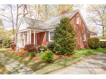 Charming brick home with a well-maintained front yard, mature trees, and inviting front porch at 920 N Sixth St, Albemarle, NC 28001
