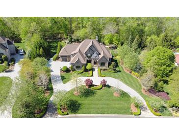 Stunning aerial view of an estate home with lush landscaping and a circular driveway nestled among mature trees at 1012 Shippon Ln, Waxhaw, NC 28173