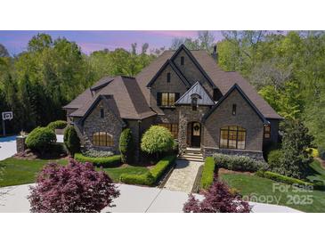 An impressive brick home with stone accents, well-manicured lawn and lush landscaping create an inviting curb appeal at 1012 Shippon Ln, Waxhaw, NC 28173