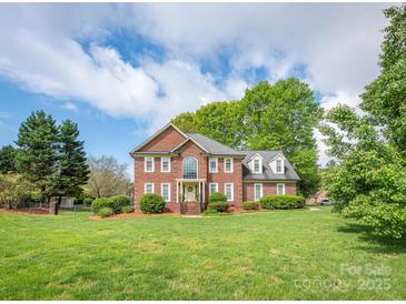 Stunning brick home with well-manicured front lawn and mature trees, offering classic elegance and curb appeal at 126 Pointer Se Ct, Concord, NC 28025