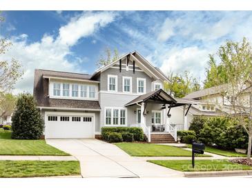 Charming two-story home featuring a well-manicured lawn, two-car garage, and inviting front porch at 1550 Matthew Mcclure Cir, Davidson, NC 28036