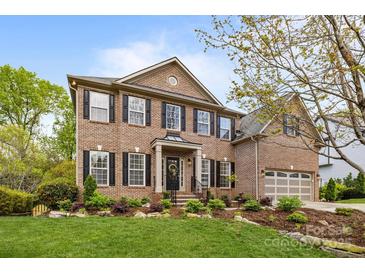 Beautiful brick home with manicured lawn and mature landscaping; a welcoming front entrance at 1809 Robbins Meadows Dr, Waxhaw, NC 28173