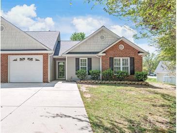 Charming single-story home featuring a brick facade, well-manicured lawn, and a two-car garage at 219 Edinburgh Ct, Mount Holly, NC 28120